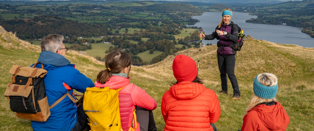 A guide from Hiking Highs speaks to a group of visitors while on a guided walk in the Lake District, Cumbria